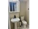 Bathroom featuring a modern pedestal sink with a black faucet and a toilet on a tiled floor at 1815 Townhall Ln # 1815, Orlando, FL 32807