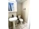 Bathroom featuring a modern pedestal sink with a black faucet and a toilet on a tiled floor at 1815 Townhall Ln # 1815, Orlando, FL 32807