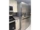 A modern refrigerator and sleek black cooktop are featured in the kitchen at 1815 Townhall Ln # 1815, Orlando, FL 32807