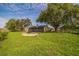 Large backyard featuring green grass, large mature trees, and a screened-in porch at 1840 Orange View Ct, Kissimmee, FL 34746