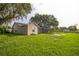 Spacious backyard with large trees, green grass, and a screened-in patio at 1840 Orange View Ct, Kissimmee, FL 34746