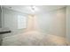 A bright bedroom with neutral carpeting, a ceiling fan, and a large window at 1840 Orange View Ct, Kissimmee, FL 34746