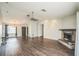 Open-concept living room boasts wood floors, vaulted ceiling, a ceiling fan, and a cozy brick fireplace at 1840 Orange View Ct, Kissimmee, FL 34746