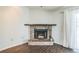 Close-up of a rustic brick fireplace in a living room with wood floors and a white curtain at 1840 Orange View Ct, Kissimmee, FL 34746