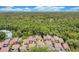Overhead view of tan townhouse-style condos nestled in lush greenery with a tennis court visible in the background at 2142 Woodbridge Rd, Longwood, FL 32779