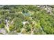 Stunning aerial view showcases a clear swimming hole, beach area, and lush greenery at 2142 Woodbridge Rd, Longwood, FL 32779