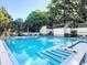 Sparkling pool with clear blue water, surrounded by a serene setting with lush greenery and lounge chairs at 2142 Woodbridge Rd, Longwood, FL 32779