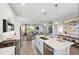 A modern kitchen showcases an island with sink and dishwasher, stainless steel appliances, and open to the living room at 2583 Long Pine Ave, Apopka, FL 32712