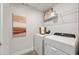 Efficient laundry room featuring modern washer and dryer, complemented by stylish decor and ample shelving at 2583 Long Pine Ave, Apopka, FL 32712