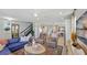 Open-concept living space with designer furnishings, elegant staircase, and seamless flow into the dining area at 2583 Long Pine Ave, Apopka, FL 32712