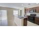 Well-lit kitchen featuring dark cabinets, tile floors, and stainless steel appliances at 2901 Ashford Park Pl, Oviedo, FL 32765