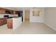 A kitchen with wood cabinets and black appliances has an open concept to the living area at 2901 Ashford Park Pl, Oviedo, FL 32765