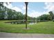 Scenic pond view on a sunny day with mature trees along the green lawn at 2901 Ashford Park Pl, Oviedo, FL 32765