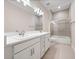 Bathroom featuring double sinks, quartz countertops, and a glass-enclosed shower-tub combination at 2922 Reef Knot Pl, Winter Park, FL 32792