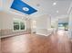 Open dining room with hardwood floors, large window, and tray ceiling featuring a unique blue center and chandelier at 2922 Reef Knot Pl, Winter Park, FL 32792