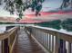 Wooden dock on a tranquil lake, with pink and purple hues across the horizon at sunset at 2922 Reef Knot Pl, Winter Park, FL 32792