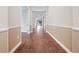 Bright hallway with hardwood floors and wainscoting offers a clear view towards the screened lanai at 2922 Reef Knot Pl, Winter Park, FL 32792