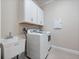 The laundry room has a utility sink, washer, dryer, and storage cabinets at 2922 Reef Knot Pl, Winter Park, FL 32792