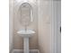 This powder room features a pedestal sink, an oval mirror, and neutral wall color at 2922 Reef Knot Pl, Winter Park, FL 32792