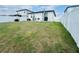 Spacious backyard featuring a white fence, grassy lawn, and patio area with a table and chairs at 29783 Anahid Dr, Leesburg, FL 34748