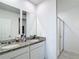 Bathroom featuring double granite vanities, a shower, and dual mirrors at 29783 Anahid Dr, Leesburg, FL 34748