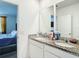 Bathroom features a double granite vanity with view into the bedroom at 29783 Anahid Dr, Leesburg, FL 34748