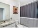 Bathroom features a granite vanity, toilet, and shower with a black and white striped shower curtain at 29783 Anahid Dr, Leesburg, FL 34748