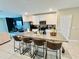 Modern kitchen featuring a large granite island with seating and stainless steel appliances at 29783 Anahid Dr, Leesburg, FL 34748