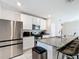 Modern kitchen featuring stainless steel appliances, granite countertops, and a breakfast bar at 29783 Anahid Dr, Leesburg, FL 34748