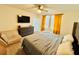 Inviting main bedroom featuring a ceiling fan, a dresser, a sofa, and ample natural light from two windows at 29783 Anahid Dr, Leesburg, FL 34748