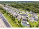 Aerial view of houses in a suburban neighborhood with solar panels and lush landscaping, and close highway access at 3172 Jade Tree Pt, Oviedo, FL 32765