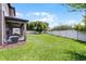 A spacious backyard offering an expansive lawn, enclosed by a pristine white fence, and shaded by mature trees at 3172 Jade Tree Pt, Oviedo, FL 32765
