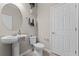 Powder room with pedestal sink, tiled floors, decorative mirror, and neutral paint at 3172 Jade Tree Pt, Oviedo, FL 32765