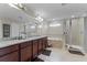 Well-lit bathroom with double vanity, soaking tub, glass-enclosed shower, and tile flooring at 3172 Jade Tree Pt, Oviedo, FL 32765