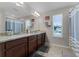 Spacious bathroom with double vanity, dark wood cabinets, granite counters, and a large mirror at 3172 Jade Tree Pt, Oviedo, FL 32765
