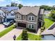 Aerial view of a two-story home with a brick driveway and mature trees at 3172 Jade Tree Pt, Oviedo, FL 32765