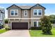 Two-story home with a brown garage door, brick driveway, and well-maintained landscaping at 3172 Jade Tree Pt, Oviedo, FL 32765