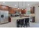 Kitchen featuring a large island with seating, granite countertops, stainless steel appliances, and dark wood cabinets at 3172 Jade Tree Pt, Oviedo, FL 32765