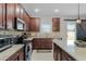 Spacious kitchen showcasing granite countertops, stainless steel appliances, and dark wood cabinetry at 3172 Jade Tree Pt, Oviedo, FL 32765