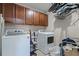 Organized laundry room with modern washer and dryer, overhead cabinets, and storage shelves at 3172 Jade Tree Pt, Oviedo, FL 32765
