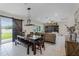 Open-concept living and dining area featuring tile floors, a dark wood table, and sliding barn doors at 3172 Jade Tree Pt, Oviedo, FL 32765