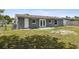 Grey house with backyard view featuring a patio, grassy yard and fenced boundary at 325 Little Aspen Ct, Ocoee, FL 34761