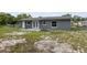 Backyard view of a grey house featuring a patio, large yard and perimeter fence at 325 Little Aspen Ct, Ocoee, FL 34761