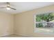 Neutral bedroom with window overlooking the backyard with a large shady tree at 325 Little Aspen Ct, Ocoee, FL 34761