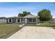 Single-story home with a gray exterior and white trim, plus a chain-link fence and concrete driveway at 325 Little Aspen Ct, Ocoee, FL 34761