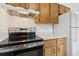 Stainless steel range, oven and hood next to wooden kitchen cabinets and a white refrigerator at 325 Little Aspen Ct, Ocoee, FL 34761