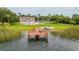 Full view of the dock, pool, tennis courts, and building from across the lake at 4312 Lake Underhill Rd # 19-B, Orlando, FL 32803