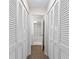 Hallway with wood floors and white shuttered closet doors and a view of a bathroom at 4312 Lake Underhill Rd # 19-B, Orlando, FL 32803