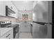 Well-lit kitchen featuring stainless steel appliances, white cabinetry, and a window overlooking the outdoors at 4312 Lake Underhill Rd # 19-B, Orlando, FL 32803