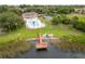 Aerial view of a lakeside community with a dock, colorful kayaks, a pool, and lush greenery at 4312 Lake Underhill Rd # 19-B, Orlando, FL 32803